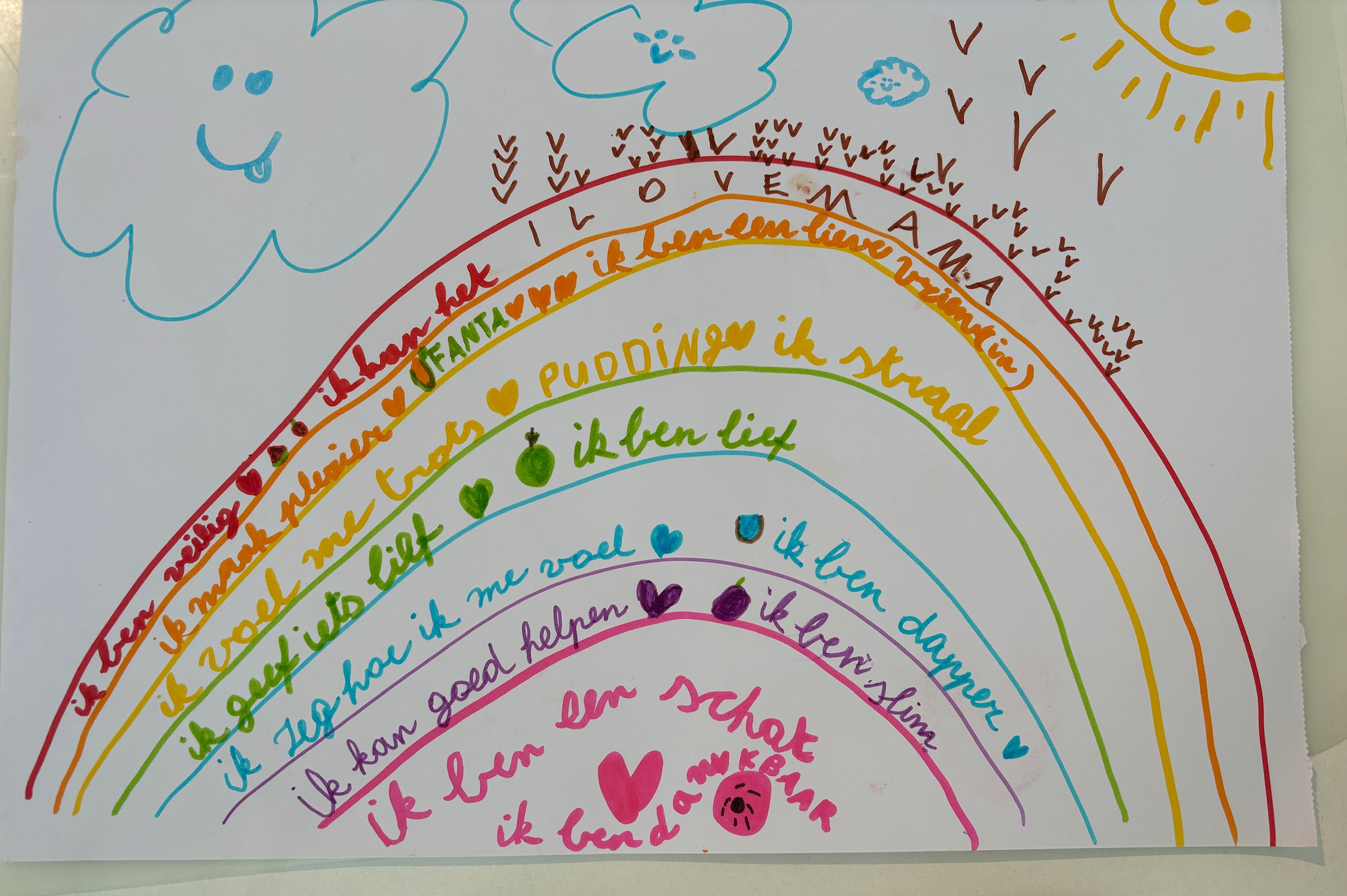Kleurrijke regenboogtekening met positieve boodschappen van een kind