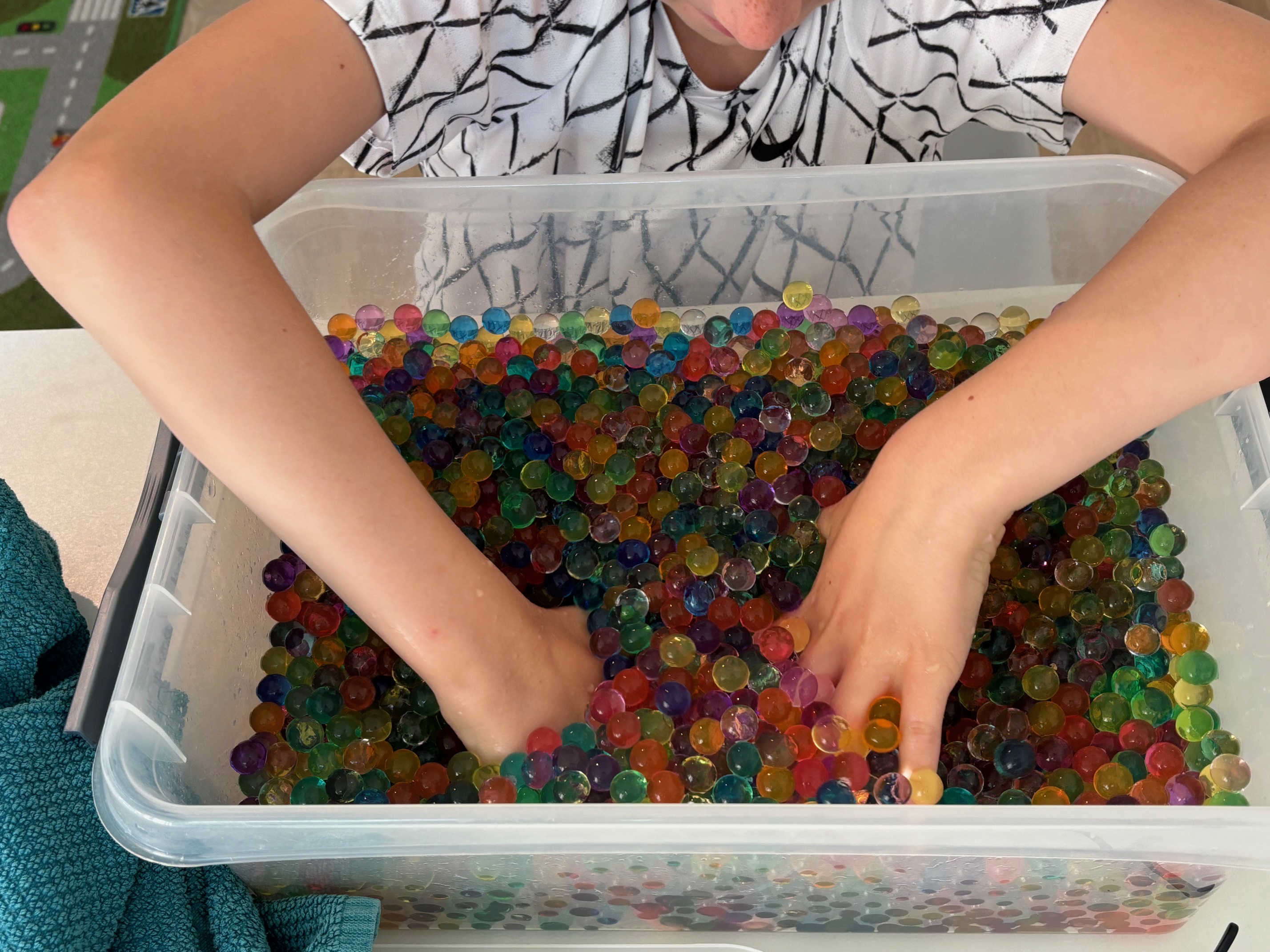 Kind speelt met kleurrijke waterballetjes tijdens een sessie