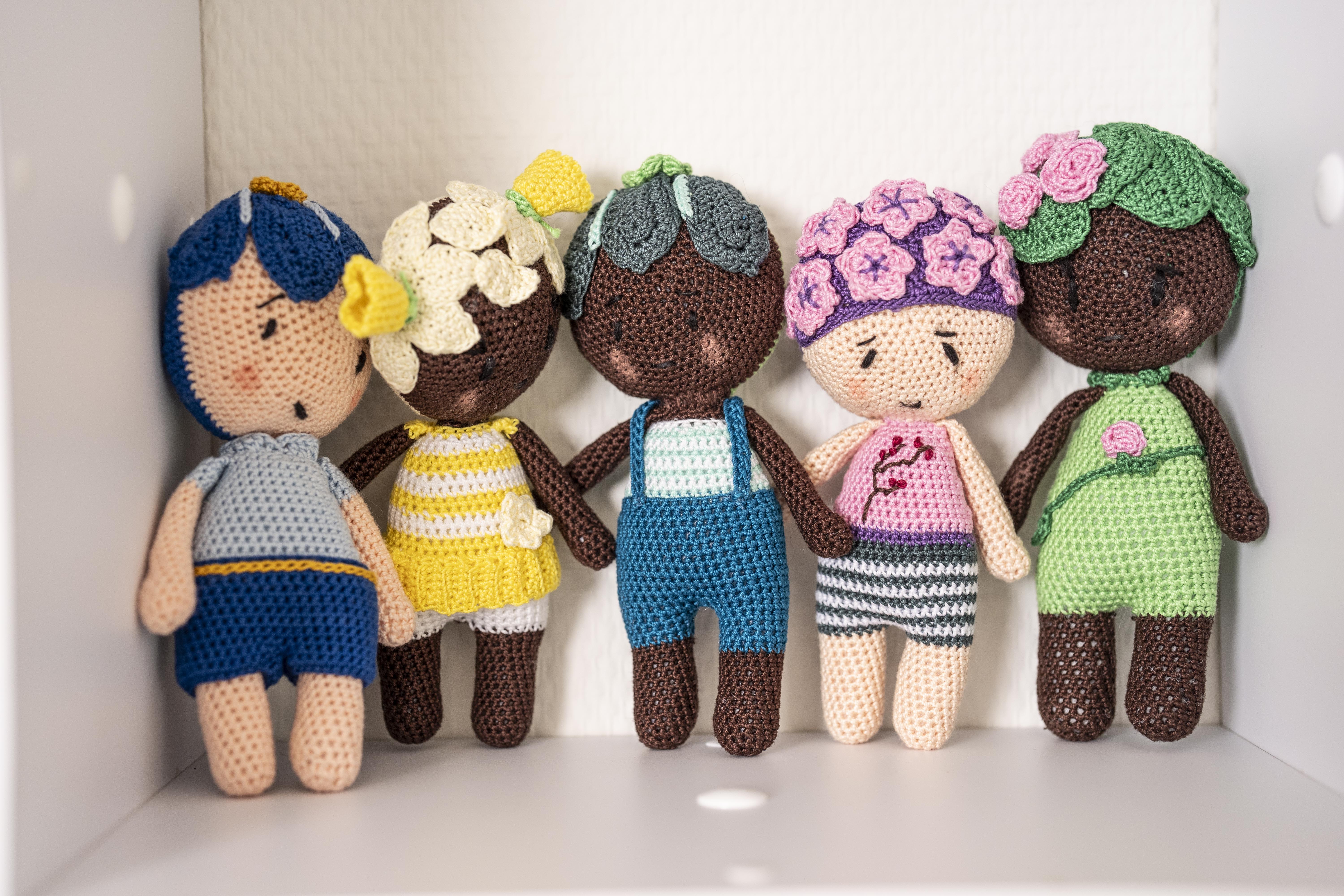Vijf diverse gehaakte poppetjes op een rij