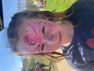 Kind met flamingo schmink op een buitenevenement